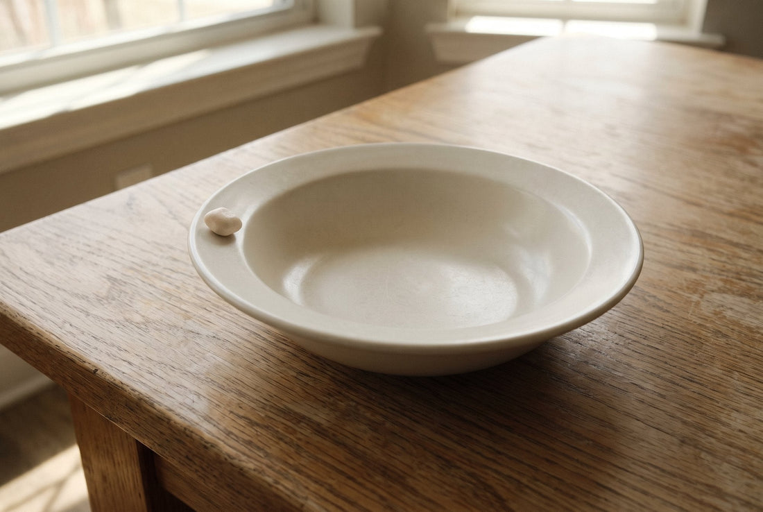 An almost empty white dish with a single gum pellet on an oak table